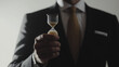 © FH Media Design - businessman in suit holding hourglass in his hand. white wall background. representing limited time for investing. buying and selling on the market at the right time