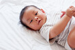 © krongthip - Cute little baby smiling and lying on a white bed.