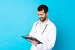 © luismolinero - Young caucasian man over isolated background wearing a doctor gown and holding a folder