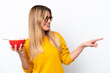 © luismolinero - Young Uruguayan woman holding a bowl of cereals isolated on white background pointing to the side to present a product