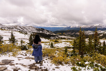 A Winter’s Embrace: A Tourist Woman Exploring Cottonwood Pass’s Snowcapped Mountains, Traveling in Colorado