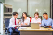 © Phushutter - In a professional office setting, two men and two women, boss and subordinates, celebrate reaching business target. They sit together, smiling, laptops and desks, sharing success and congratulations.