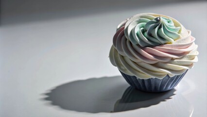 Poster - A single cupcake with a swirl of pastel pink, white and blue frosting, casting a shadow on a white surface.