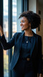 © Michael - Young businesswoman smiles while holding window pane and looking out office window