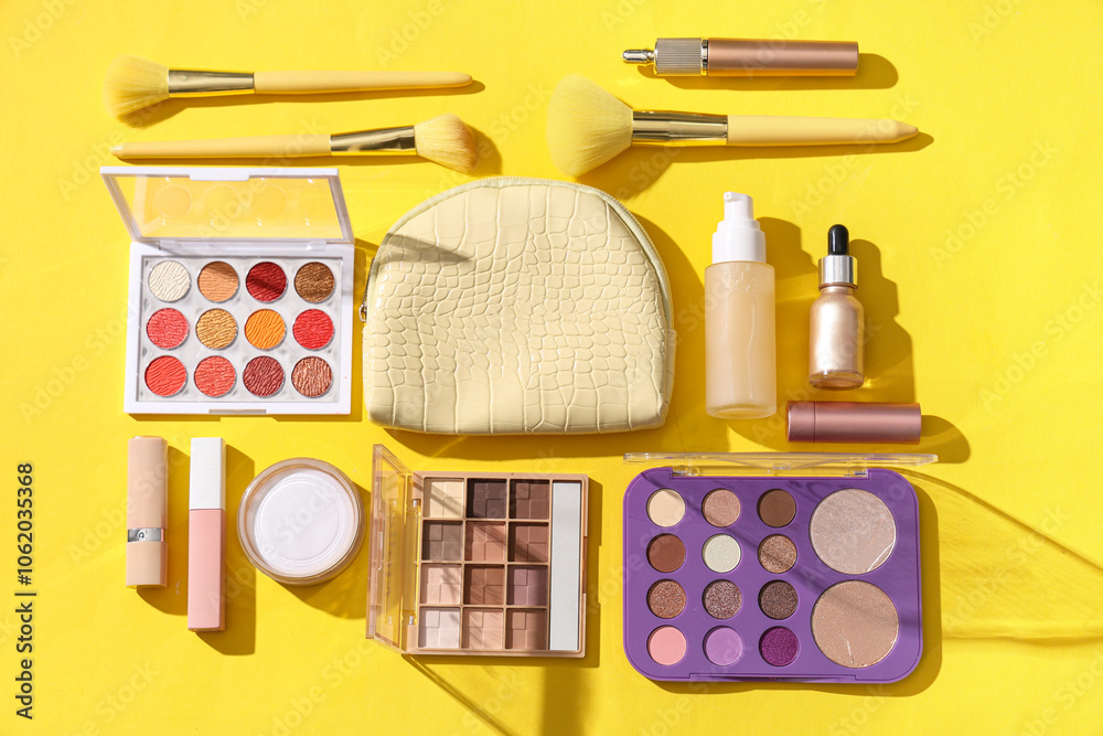 Cosmetic bag and makeup products on yellow background