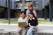 © amnaj - Asian students working together on a laptop, enjoying the pleasant outdoor environment of their university campus