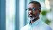 © Manon - Confident professional man smiling in stylish office setting enhances workplace atmosphere and productivity