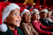 © Katie R - group of happy kids in santa hats watching christmas performance in a theater