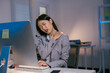 © Parichat - Young office worker is massaging her neck and shoulder while working on a computer in the office at night, suffering from chronic pain after a long day