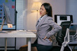 © Parichat - Young manager having backache after long time working on computer, incorrect posture problems, suffering from back pain, sedentary lifestyle, health problems concept