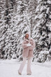 © Tatyana - Young happy attractive woman in a light hat and fur coat in a winter forest. Winter concept.