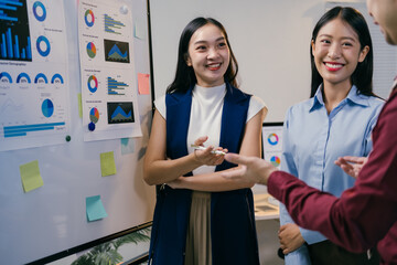 Poster - Three asian businesswomen are discussing charts and statistics during a meeting, sharing ideas and strategies for their company's success