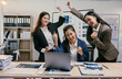 © PaeGAG - Three asian businesswomen are cheering and celebrating their success while looking at a laptop in a modern office, expressing joy and teamwork
