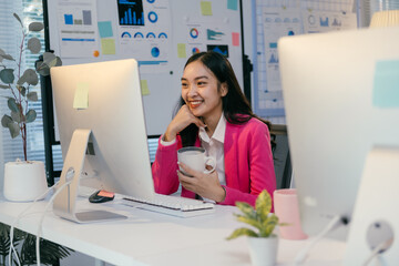 Aufkleber - Young entrepreneur enjoying a cup of coffee while working on her computer in a modern office, showcasing a positive and productive work environment