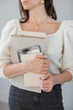 © RooM The Agency - Close-up of a stylish woman in casual clothing standing in an office holding a notepad, paperwork and a digital tablet