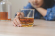 © KMPZZZ - Alcoholism drunk, sad asian young woman hand holding glass of alcohol or whiskey, alone depressed female drink booze on background. Treatment of alcohol addiction, suffer abuse problem alcoholism.