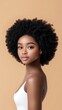 © Espresso - A young Black woman with a beautiful afro hairstyle poses gracefully against a warm, neutral backdrop.