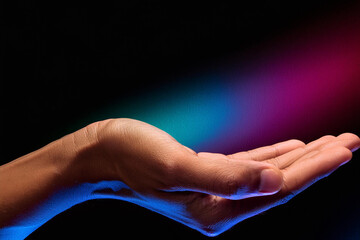 Two hands showing a sale advertisement copy space and black background with burst of colors with colorful glitter style