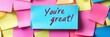 © Barosanu - A blue sticky note at the center with the words ‘You're great!’ surrounded by various colorful notes, creating an overall soothing yet vibrant visual stimulating and positive encouragement.