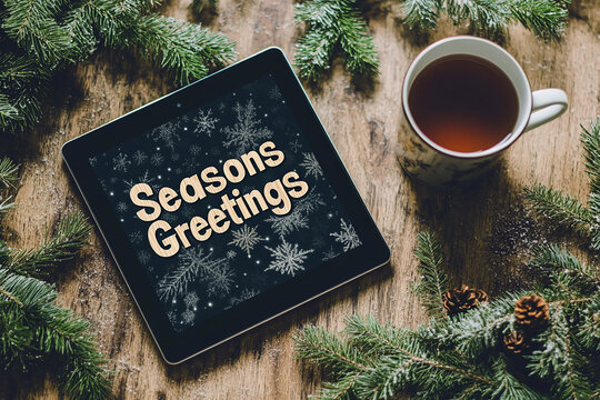 Welcomed season's greeting card with the words SEASONS GREETINGS on an iPad tablet screen