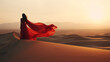 © PNPImages - Beautiful exotic Middle Eastern woman standing on a sand dune in the desert with flowing red dress blowing in the wind