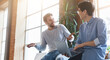 © Prostock-studio - Two young multiracial coworkers having conversation during break time in office, copy space