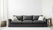 © G.Go - A large gray couch sits in a room with a white wall