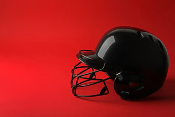 Black baseball helmet on red background, space for text