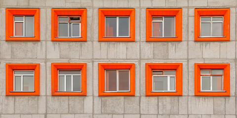 Poster - Orange window frames creating a pattern on a concrete wall