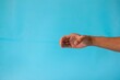 © fadfebrian - A man's hand with a pose or gesture of holding or showing something on a blue background
