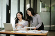 © Thitisak - Two business women sitting and working Documents in front of the computer