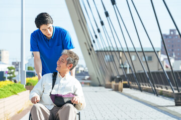 Poster - 介護、介護士、車椅子、外出、ヘルパー、シニア、高齢者、お年寄り、街、笑顔、都市、社会、ウェルネス、福祉、ケアスタッフ、スタッフ、介助、老後、介護福祉士、橋、道路、歩道、バリアフリー、障害者、障害、ホームヘルパー、散歩、屋外、サービス、サポート、訪問、介護員、自立支援、リハビリ、健康、ヘルスケア、デイサービス、老人ホーム、付き添い、施設、青空、ポジティブ、元気、明るい、リラックス、男性、日本人、歩く