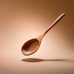 Wall Mural - Wooden spoon floating or flying isolated on biege background