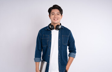 portrait of asian male student wearing cable and headphones posing on white background