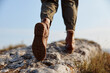 © SHOTPRIME STUDIO - Person walking on top of mountain with feet on rock in scenic nature landscape adventure travel concept