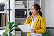 © David - Asian busty employee, Young asian business woman holding paper while working and talking phone at office table, Happy office girl working, business people casual lifestyle