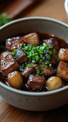 Filipino adobo in a bowl, rich dark soy glaze, subtle shadows, elegantly simple garnish, inviting presentation