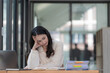 © Songsak C - Frustrated Asian beautiful businesswoman feeling depressed, exhausted, tired, and lazy during working at the office.