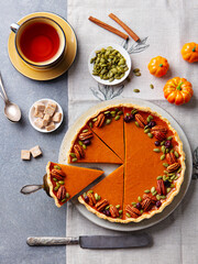 Wall Mural - Pumpkin pie, tart made for Thanksgiving day with cup of tea. Grey stone background. Top view.