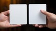 © Iuliia - A close-up of two hands holding blank white cards side by side