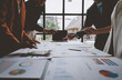 © Phimwilai - Group of business men and women meeting, pointing at graphs, charts Work together on the table to analyze data. strategic planning Market growth for office real estate projects business concept.