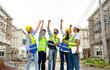 © bigy9950 - Group of contractors, engineers and formats in safety vests with helmets hands up to work together to successfully complete a construction project on construction site. cooperation and success