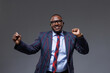 © st.kolesnikov - confident handsome african businessman dancing, on gray background, successful business concept