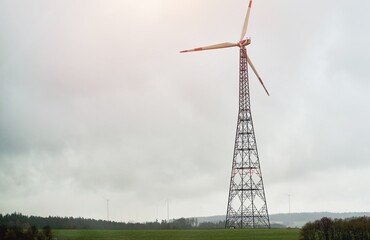 Wall Mural - Wind turbine standing tall in rural agricultural landscape