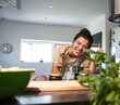© Westend61 - Cheerful woman cooking food at home