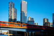 © yaqui_villegas - A vibrant city skyline view featuring a train crossing a bridge against the backdrop of tall skyscrapers at sunset, symbolizing connectivity and urban progress  in London UK