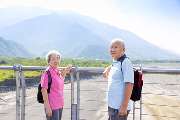 Wall Mural - Travel and tourism. Senior family couple walking together on bridge