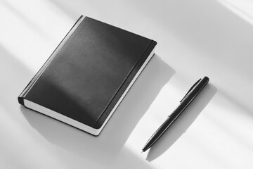 Aufkleber - A sleek black notebook and pen are expertly positioned on a white surface, creating a minimalist atmosphere perfect for professional or casual settings.