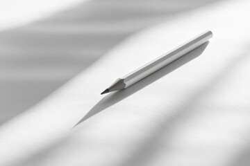Aufkleber - A white pencil on a plain sheet of paper casting soft shadows, offering insights into minimalistic beauty through simple yet impactful composition and lighting.