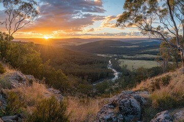 Poster - The sun sets over forested hills with a river winding through, casting a warm glow and creating a picturesque, tranquil scene that evokes peace and natural beauty.